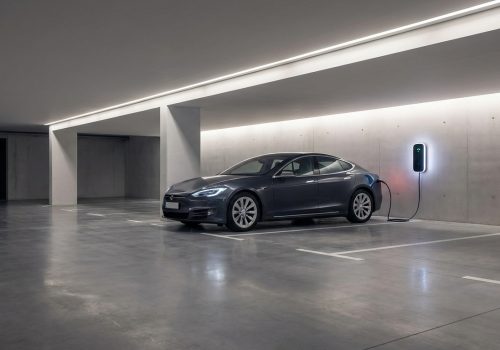 עמדת טעינה לרכב חשמלי מותקנת כחוק בחניון תת-קרקעי של בניין משותף.