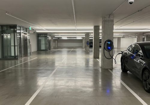 חניון תת קרקעי של בניין מגורים מודרני עם עמדת טעינה מותקנת
